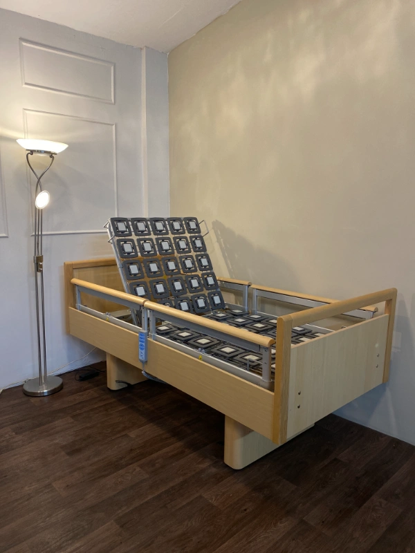 Ápolási ágy emelt háttámlával, oldalkorláttal és modern designnal.