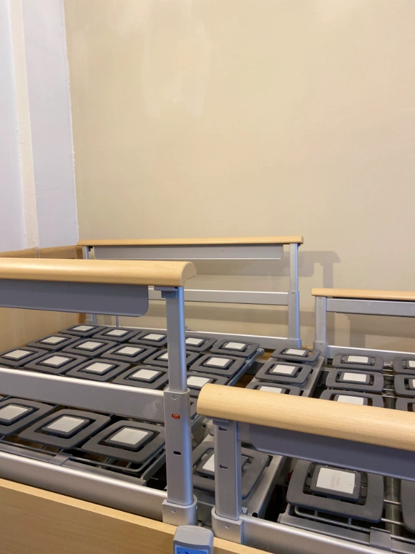 Osztott korláttal és több ponton állítható szerkezettel felszerelt kórházi ágy.
