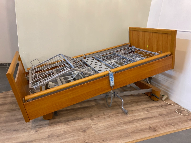 Elektromos kórházi ágy döntött helyzetben, fa borítással, távirányítóval.