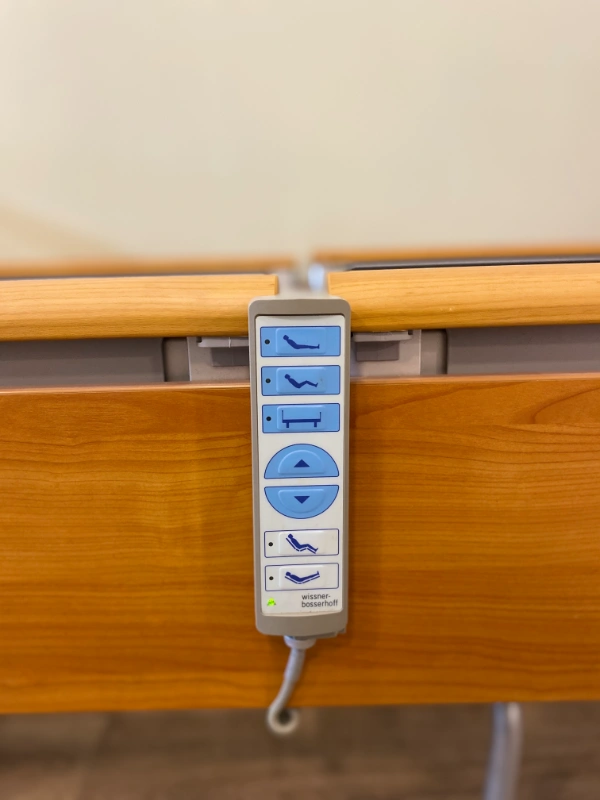 Wissner-Bosserhoff márkájú használt elektromos betegágy távirányítóval, fa borítással.
