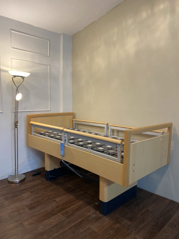 Többfunkciós betegágy fa burkolattal és állítható oldalkorláttal.